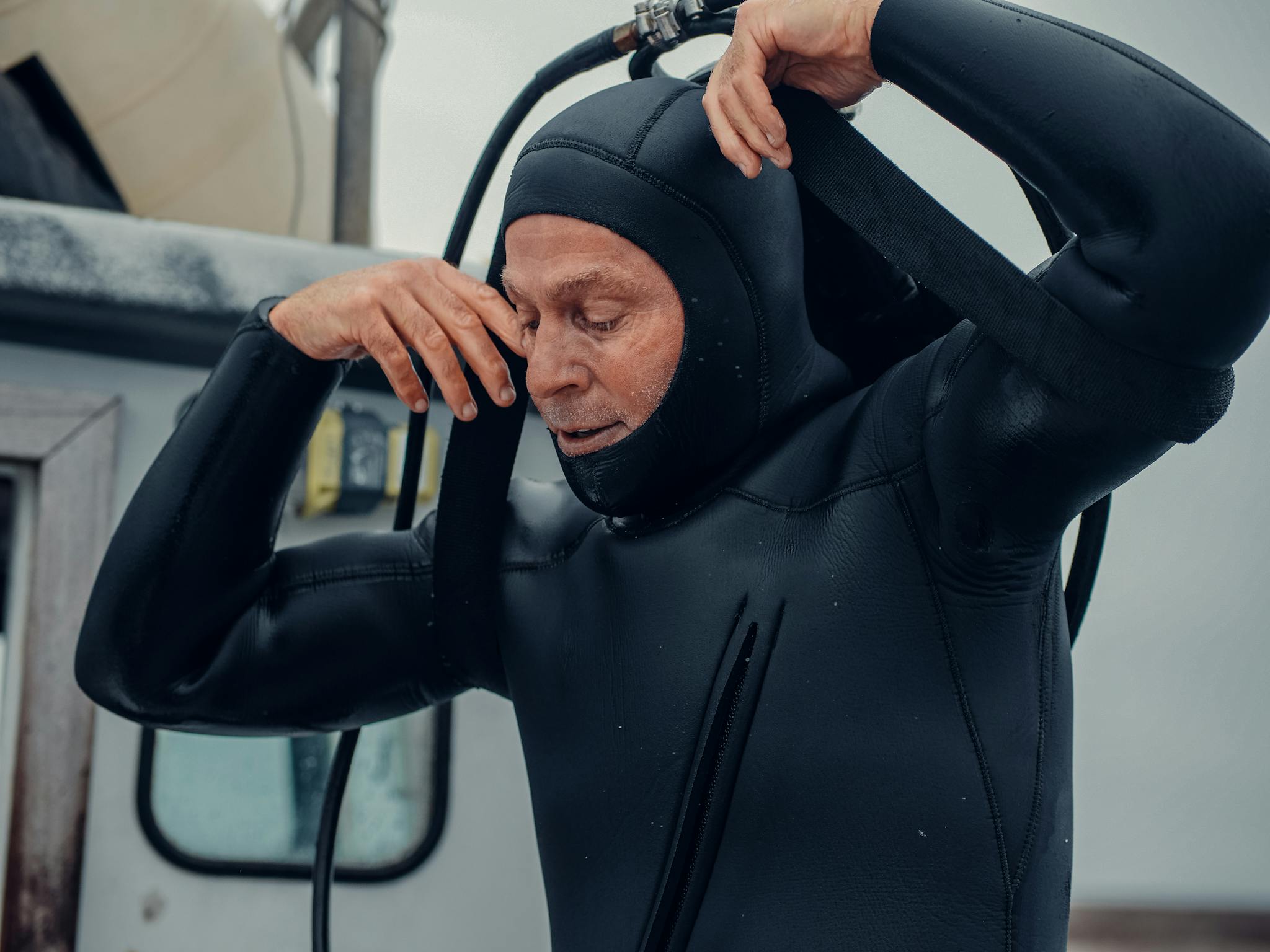 A seasoned diver adjusts his wetsuit, ready for an underwater exploration.